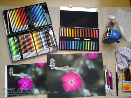 Buntstifte, Pastellkreiden und Zeichnungen von einer Blume auf einem Tisch.