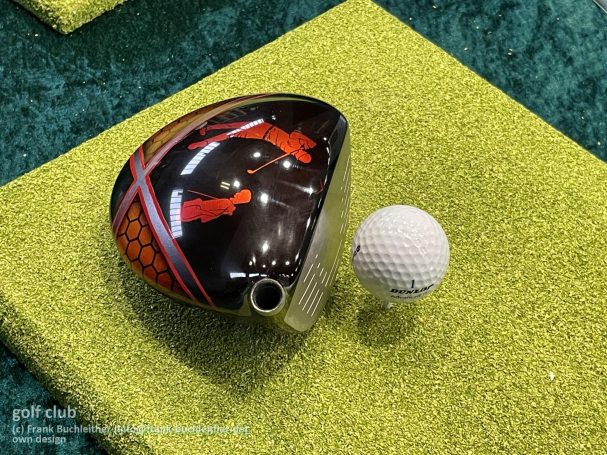 Schwarze Golfschläger mit rotem Design, daneben ein Golfball.