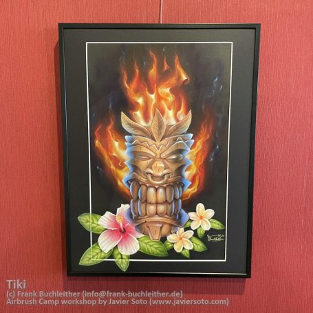 Ein Tiki mit Feuerglanz, umgeben von Blumen, an einer roten Wand.